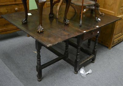 Lot 1221 - A late 18th century drop leaf oak dining table