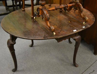 Lot 1231 - A 19th century oak oval drop leaf table on pad feet