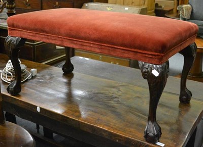 Lot 1239 - A large footstool with red velvet upholstery on claw and ball feet