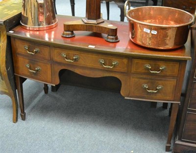 Lot 1244 - An Edwardian mahogany bow front writing desk with red leather top