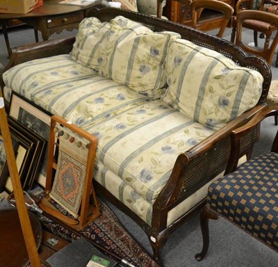 Lot 1279 - An early 20th century bergere settee with floral upholstered soft cushions