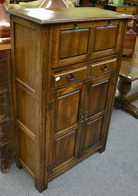 Lot 1298 - A modern panelled oak cupboard with two drawers