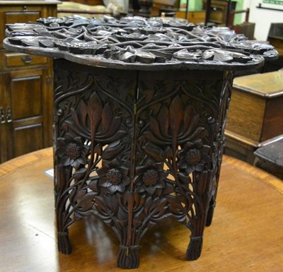 Lot 1308 - An Eastern folding table with detachable top carved with foliate motifs, possibly retailed by...