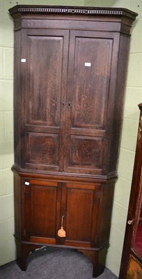 Lot 1327 - A Georgian oak corner cupboard on later stand