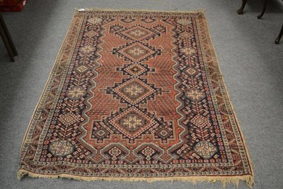 Lot 1363 - An Ashfar rug, South East Persia, terracotta crenelated field with a column of hooked...