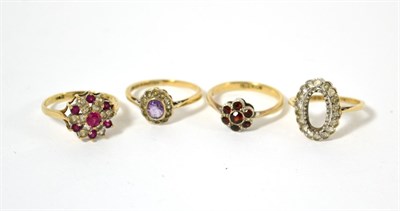 Lot 11 - An amethyst ring, two other gem set rings and a ring with central aperture where the stone has come