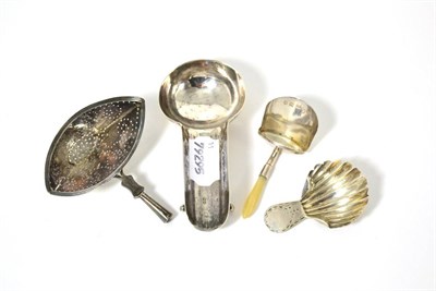 Lot 16 - A Georgian silver spoon rest, a Victorian silver strainer and two caddy spoons