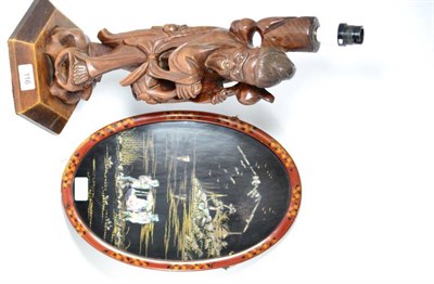 Lot 116 - A Japanese carved rootwood figure depicting a deity and an oval lacquer panel (2)