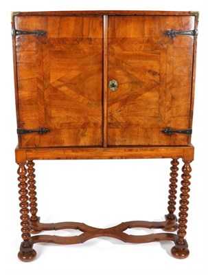 Lot 765 - A George I Walnut and Crossbanded Cabinet on Stand, with two cupboard doors crossbanded and...