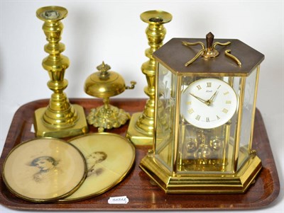 Lot 152 - A modern 400 day clock, a pair of brass candlesticks, table bell and two oval portrait prints