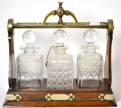 Lot 159 - A Staniforths patent three bottle oak and plated tantalus, by Fenton Bros, Sheffield with...