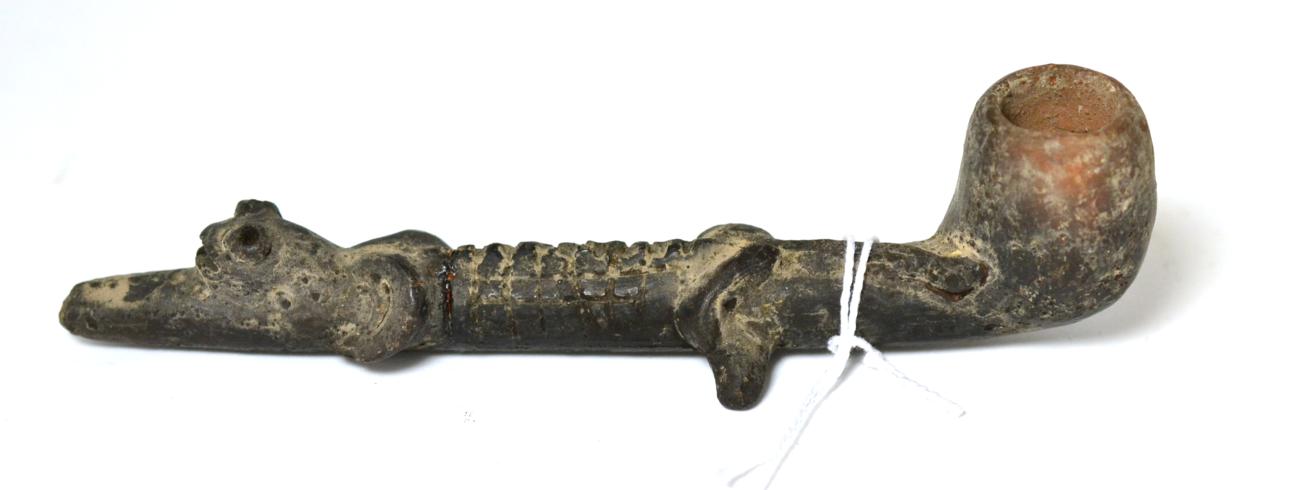 Lot 241 - A Pre-Columbian black glazed terracotta pipe modelled as a stylised crocodile, possibly Chimu Peru