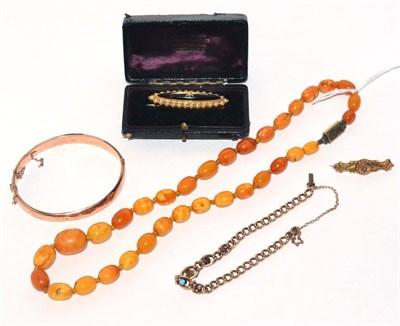 Lot 304 - An egg yolk amber bead necklace, a 9ct gold stiff hinged bangle, a 9ct gold and turquoise set...