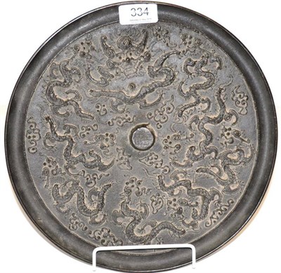 Lot 334 - A Chinese bronze disc decorated with dragons