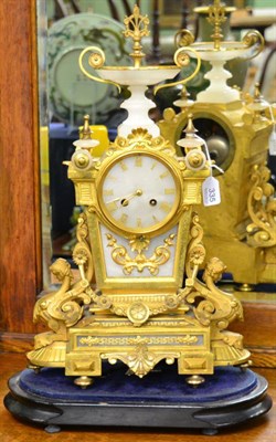 Lot 335 - A gilt metal decorative mantel clock on oval ebonised stand