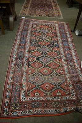 Lot 1326 - A Kurdish rug, Persian Kurdistan, the honeycomb lattice field of polychrome flowerheads enclosed by