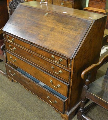 Lot 1351 - A George III oak bureau, the fitted interior with faux book drawers