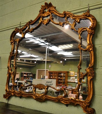 Lot 1420 - A gilt composition mirror in the Rococo taste