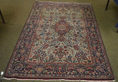 Lot 1423 - A Kashan rug, Central Persia, the ivory field of scrolling vines around a raspberry medallion...