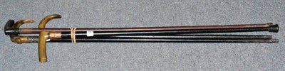 Lot 221 - Four horn handled walking canes, three with ebonised shafts and one with a collar stamped '18CTGP'