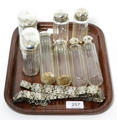 Lot 257 - A collection of eight silver topped dressing case bottles and a plated belt