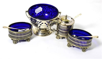 Lot 360 - A silver pedestal sugar basket with swing handle, blue glass liner and a Victorian plated three...