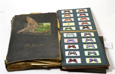 Lot 404 - A postcard album containing various WWI silks and others with two cigarette card albums (3)