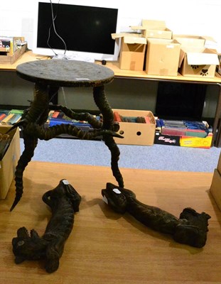 Lot 1013 - A small ebonised games table with black buck horn supports and a pair of Tibetan carved wood...