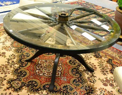 Lot 1023 - An oak cartwheel dining table with glass top