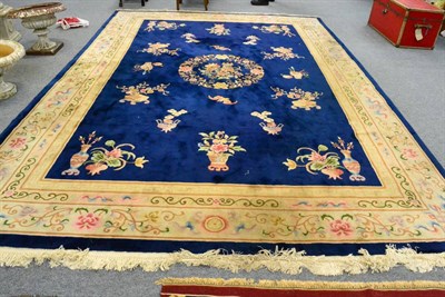 Lot 1027 - A large Chinese woolen carpet, with a central medallion of flowers and vines with an allover design