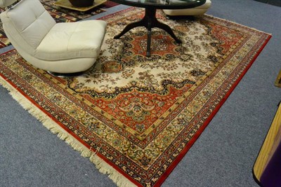 Lot 1028 - A large cream and red ground rug