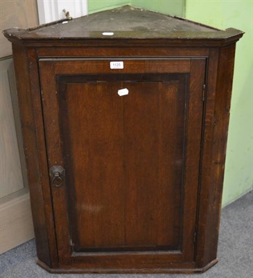 Lot 1125 - A Georgian oak hanging corner cupboard