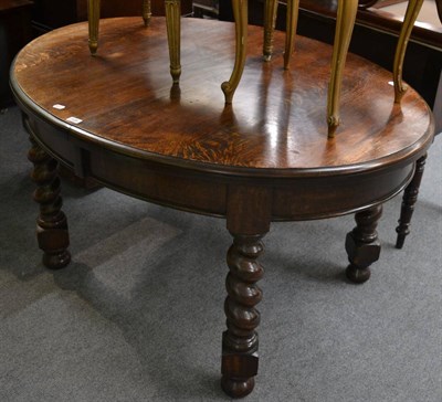 Lot 1126 - An early 20th century oak wind out dining table (lacking leaf)