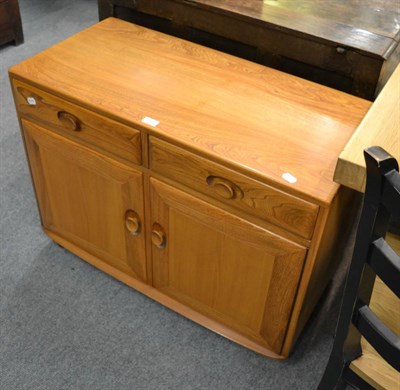 Lot 1145 - An Ercol Windsor elm wood two door high sideboard, after a design by Lucian Ercolani