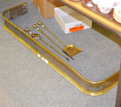 Lot 61 - Brass fender and three fire implements