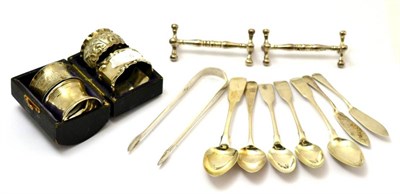 Lot 80 - Four silver napkin rings, silver teaspoons, two silver knife rests, silver sugar tongs and two...