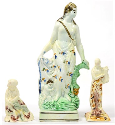 Lot 82 - A Prattware Figure of Venus and Cupid, circa 1790, the standing goddess with her hand on a dolphin