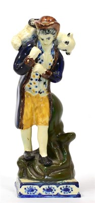 Lot 83 - A Prattware Figure of the Lost Sheep, circa 1800, modelled as a standing shepherd holding a ewe...