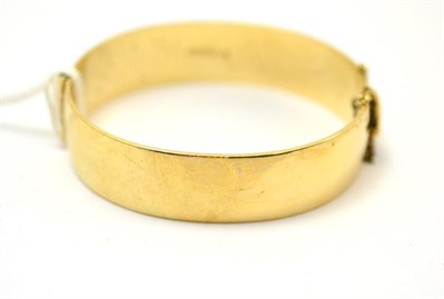 Lot 101 - A gold bangle stamped 9ct and decorated with thistles