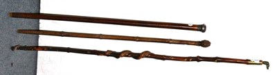 Lot 132 - A silver mounted malacca walking cane, a bamboo horse measuring stick and a wrythen carved...