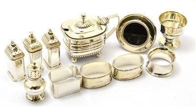 Lot 303 - Silver comprising: four napkin rings, four pepperettes, a mustard, an egg cup and a picture frame