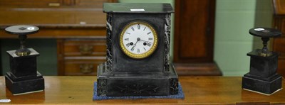 Lot 505 - A black slate striking mantel clock garniture