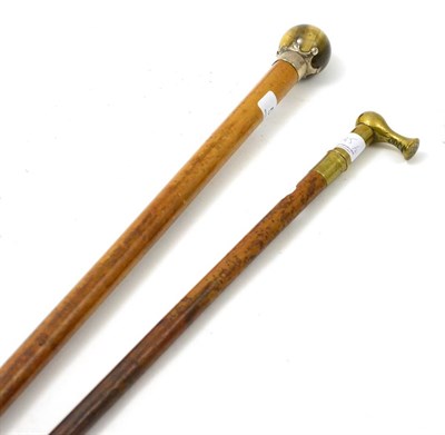 Lot 545 - A silver mounted cane with tigers eye pommel and a brass mounted riding crop