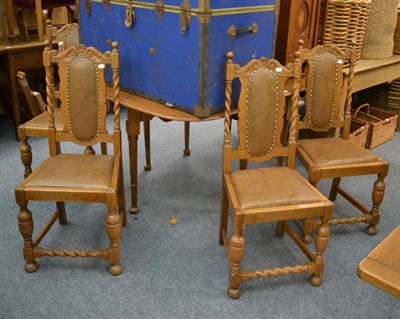 Lot 1032 - An oak drop leaf dining table and four chairs