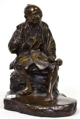 Lot 162 - A Japanese Bronze Figure of a Seated Man, Meiji period, holding implements on a shaped oval...