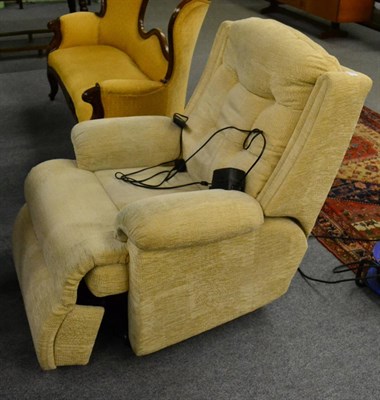 Lot 1180 - A cream velour upholstered electric reclining armchair