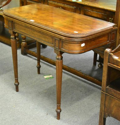 Lot 1185 - A mid-19th century mahogany fold over tea table with reeded legs