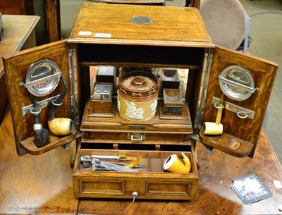 Lot 617 - A late Victorian blonde oak smokers cabinet, Chapman's patent with numerous accessories including a