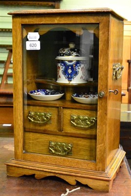 Lot 620 - A late Victorian glazed blond oak smokers cabinet fitted with pottery tobacco jar and ashtrays