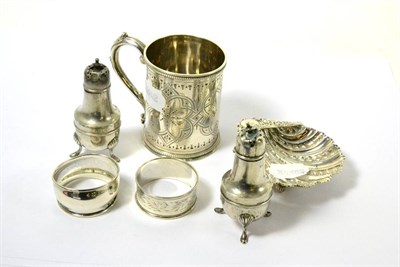 Lot 80 - A silver christening mug, shell shaped bonbon dish, two napkin rings and two peppers